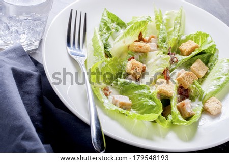 Healthy breakfast caesar salad served on a white plate.