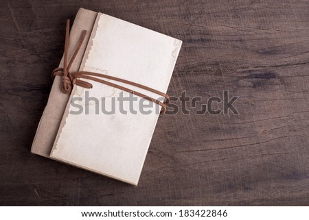 Old notebooks Was strangled with a leather strap on wooden background