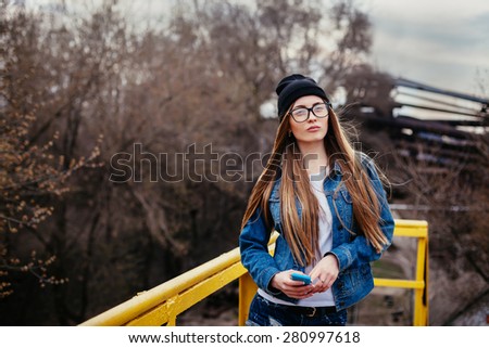 Outdoor fashion lifestyle portrait of pretty young girl, wearing in hipster swag grunge style urban background.