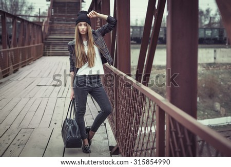 Outdoor lifestyle portrait of pretty young girl, wearing in hipster swag grunge style urban background. Retro vintage toned image, film simulation.
