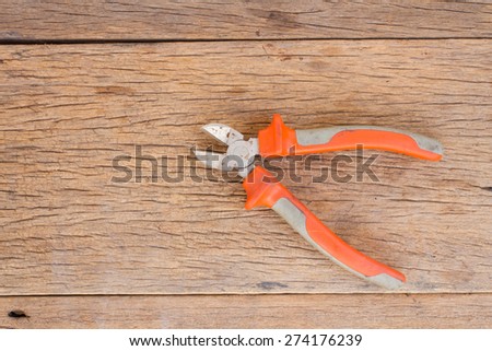 Wire cutter on wood background and space for write messege