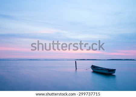 Mystical sea. Abstract natural backgrounds. Moon scene after sunset with still water and vintage boat.
