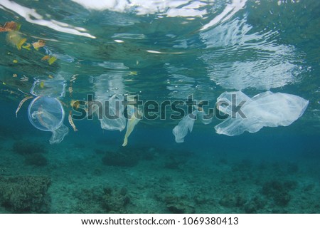 Plastic ocean pollution. Plastic bags, straws, cups and bottles discarded in sea instead of recycling. Environmental problem