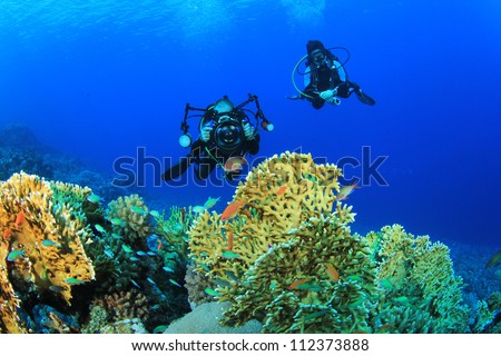 Couple Scuba Diving and taking underwater photos on a coral reef