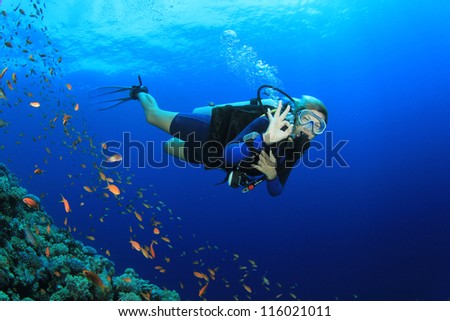Beautiful Blonde Woman Scuba Diver signals okay underwater
