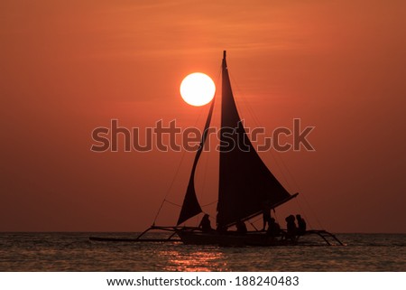 Traditional Sailboat on ocean at sunset