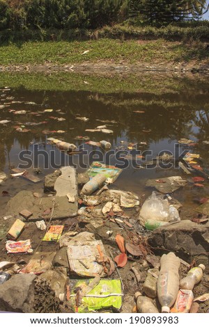 KOTA KINABALU, MALAYSIA - APRIL 26 2014: Plastic rubbish pollution in park pond. Photo showing pollution problem of litter building up in park pond due to no recycling or garbage collection services.