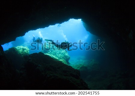 Scuba Divers enter underwater cave