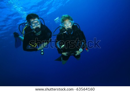 Couple Scuba Diving together over a beautiful coral reef