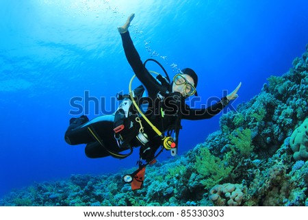 Young Woman Scuba Diver explores a Coral Reef in the Red Sea
