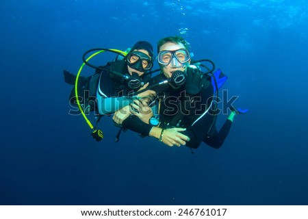Happy couple scuba diving together