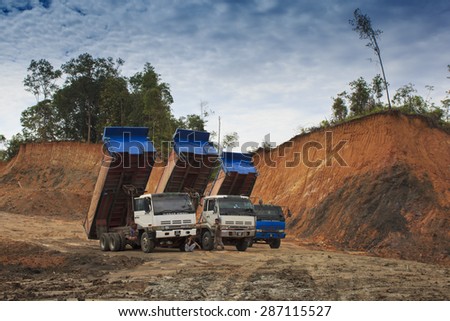 KUCHING, MALAYSIA - MAY 25 2015: Deforestation. Trucks ready to cart away timber as rain forest is destroyed in Borneo.