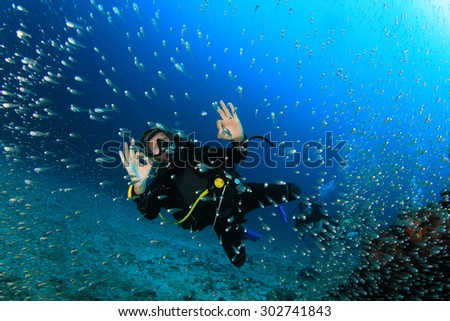 Female scuba diver explores coral reef underwater