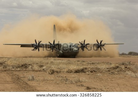 NANYUKI, KENYA - CIRCA OCTOBER 2015 - British RAF Hercules aircraft lands on field airstrip during training exercise with British Army. Government spending cuts will reduce future training like this.
