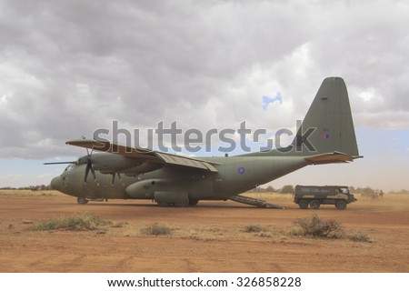 NANYUKI, KENYA - CIRCA OCTOBER 2015 - British RAF Hercules aircraft lands on field airstrip during training exercise with British Army. Government spending cuts will reduce future training like this.