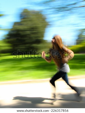 A motion blur abstract of a running girl in a park