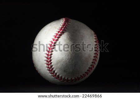 White baseball with red stitching, lit from the left, with fill light at right on a black background.