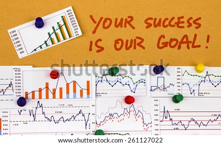 your success is our goal handwritten on paper with financial charts
