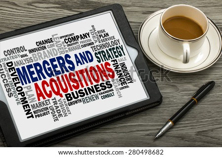 mergers and acquisitions concept with business word cloud handwritten on tablet pc