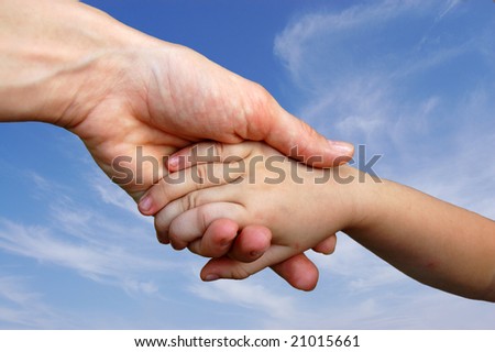 Baby hand and Mother hand on sky background