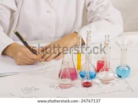 Scientist making tests in lab and writes results in a notebook