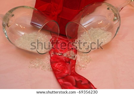 Red Gift Box with Roses Ribbon and Champagn Glasse Spilling out Glitter