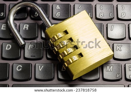 Open combination padlock on a laptop keyboard symbolizing data security
