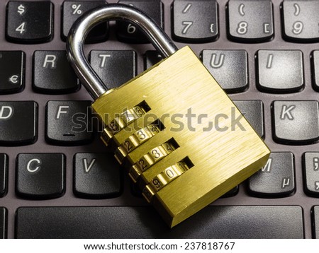 Closed combination padlock on a laptop keyboard symbolizing data security