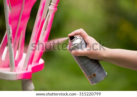 Spray painting an old chair in the color pink