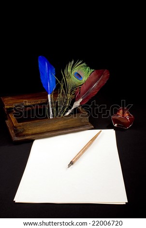 A tabletop with paper,inkwell and some writing feathers