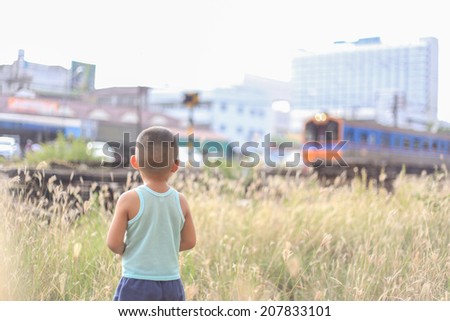Boy stands on the platform and looks after the departing train