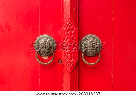 The ancient style red door, the entry way to the spirit house in the northern Thailand