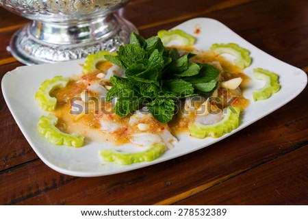 Raw shrimps in fish sauce with spicy Thai seafood sauce and mint.