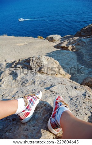 Overhead photo of feet on a background of seaview. Women feets view from above. Exploring, travelling, tourism, leisure.