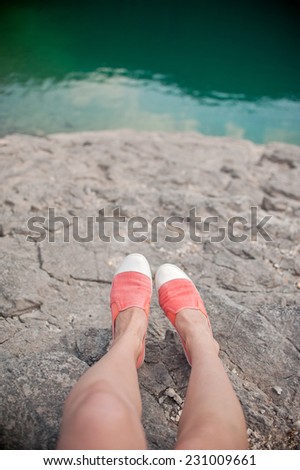 Overhead photo of feet on a background of water. Women feets view from above. Exploring, travelling, tourism, leisure.
