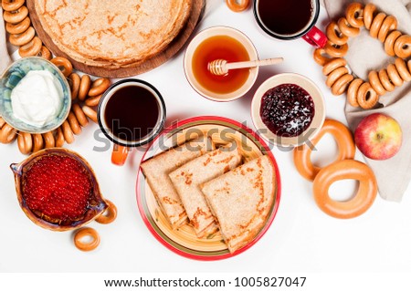 Shrovetide Maslenitsa festival meal. Russian pancake blini with raspberry jam, honey, fresh cream and red caviar on white background