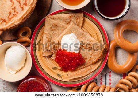 Shrovetide Maslenitsa festival meal. Russian pancakes blini with honey, fresh cream cheese and red caviar. Rustic style