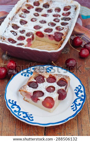Cherry Clafoutis with powdered sugar in baking dishes