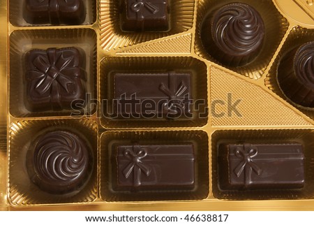 Box of chocolates inside. Dark chocolate in gold foil.