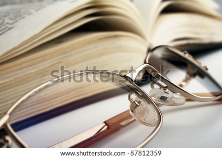 the reading glasses and open old book