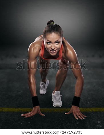 beautiful athlete on low start on a dark background isolated with clipping path