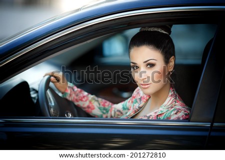 Happy Woman with car keys, female driver holding car keys driving her new car. Luxury car and girl.