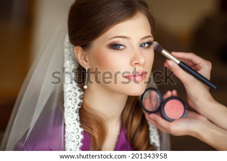 Beautiful bride wedding makeup and hairstyle. Stylist makes makeup bride on wedding day. portrait of young bride at wedding day. series. soft tonality