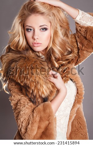 Fashion portrait sexy blond woman in elegant fur coat winter, fashionable girl vogue style. Fashion Beauty girl model with long healthy wavy hair styling.