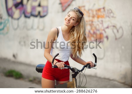 Happy young woman on bicycle, sport girl on bike, fitness lady biking on bicycle at summer , smiling girl with bike on city street, health lifestyle concept, soft focus, series