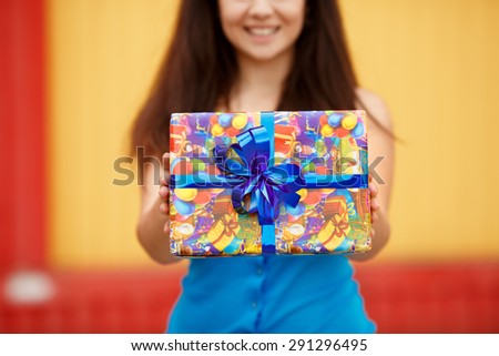 Happy young woman with gift box, smiling girl with birthday gifts outdoor, beautiful female at birthday party with present, joyful lady hold gifts outdoor portrait, instagram style color filter