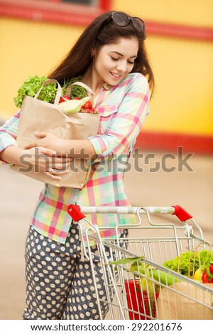 Beautiful shopping woman with vegetables, happy young girl in grocery shop with purchase bags full of organic vegetables, smiling female at supermarket buying food, instagam style filters, series