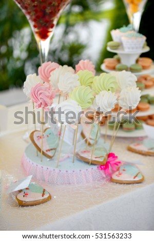 Delicious wedding candy bar or birthday party dessert table. Table with colorful sweets, candies, dessert, macaroons. Candy Bar buffet with cupcakes at restaurant.