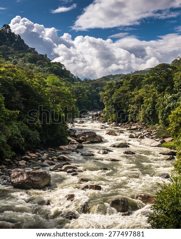 Torrent on the way between Banos and Puyo in Ecuador. White water, rocks, quick flow, strong current, forest around. Pastaza river.