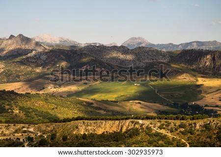 Panorama of the mountains and fields west of Ronda. Early morning light. Landscape of the mountains and hills west of Ronda. Shadow and light area coming from the  fluffy clouds on the sky.